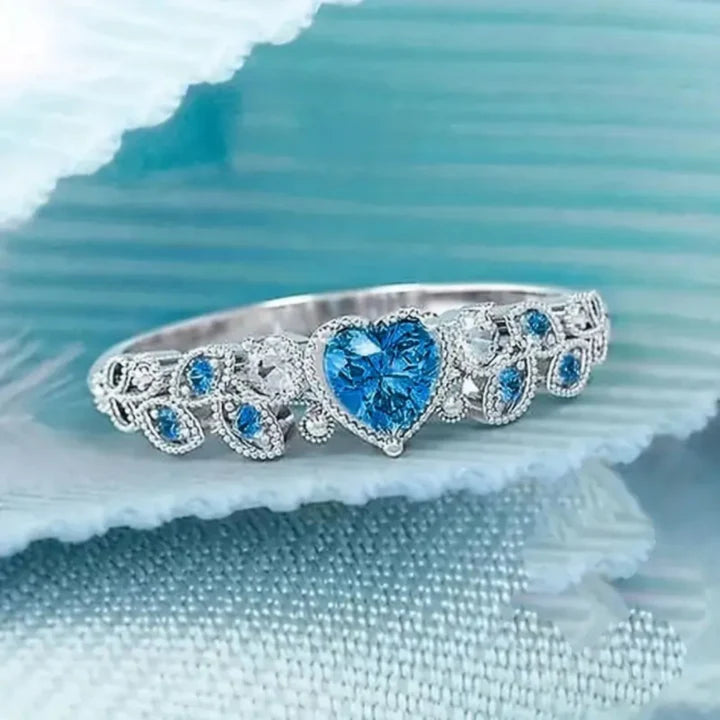 Versilberter Ring mit blauem Kristall und hellem Herz