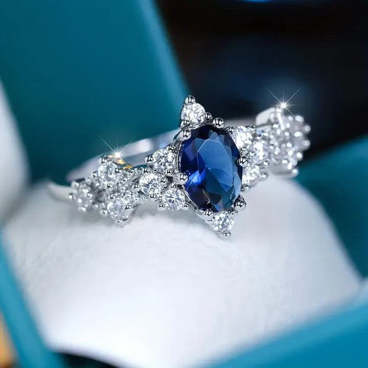 Versilberter Ring mit ovalem blauem Kristall